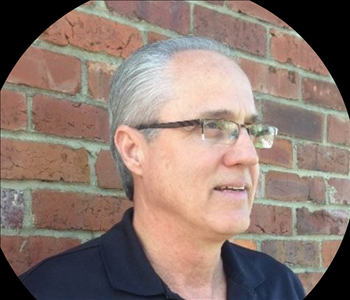 Man in front of brick wall 